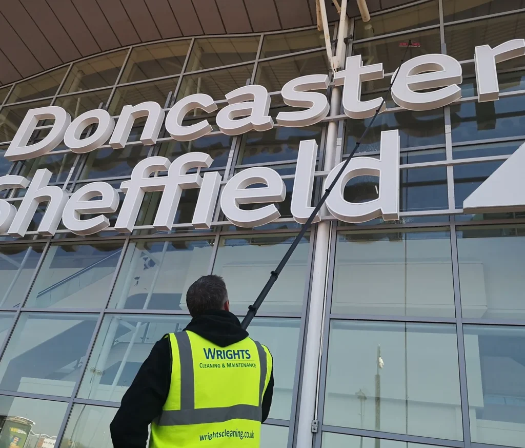 Wrights Cleaning operative in branded hi-vis cleaning airport glazing